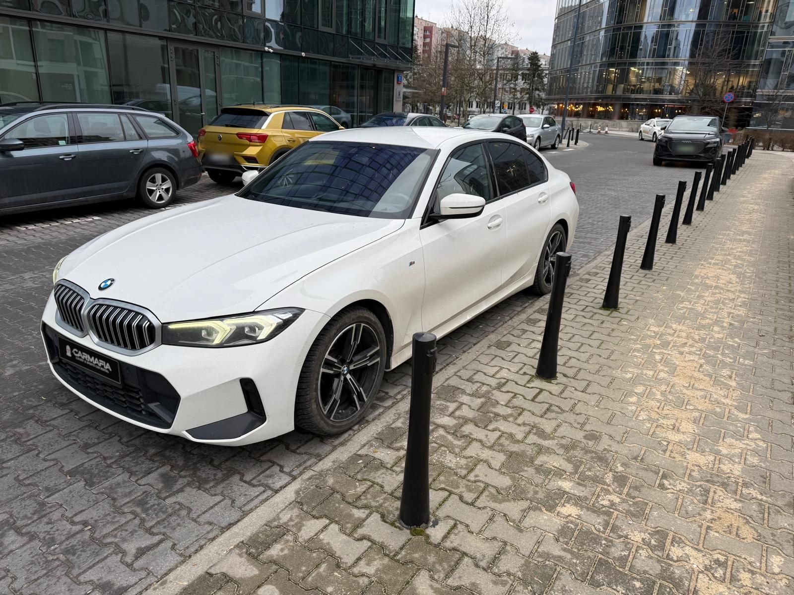 BMW 318i G20 2023 z przodu, na ulicy z zaparkowanymi autami